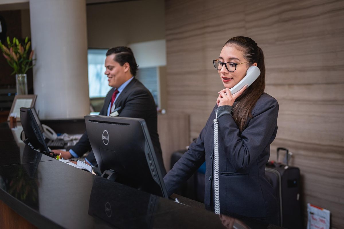 Une femme parle au téléphone, un homme travaille sur un ordinateur Une femme parle au téléphone, un homme travaille sur un ordinateur