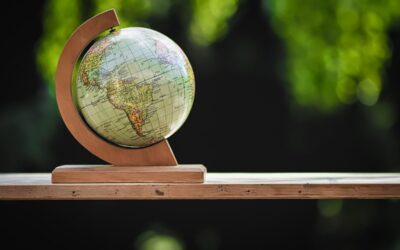 Petit globe terrestre en bois, support incurvé, sur planche, fond vert flou